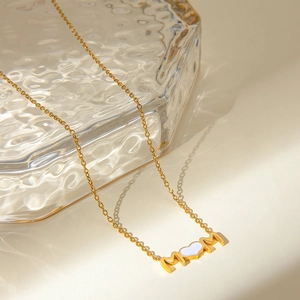 Vue détaillée du collier MOM en acier doré 18 carats avec pendentif cœur et strass brillants
