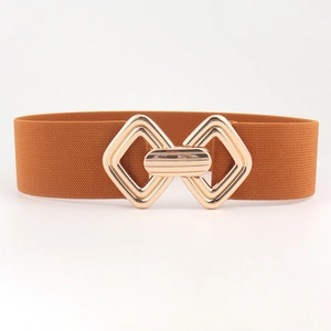 Détail d'une ceinture élastique caramel avec boucle imbriquée en métal doré brillant