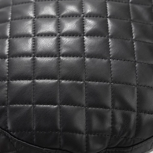 Detail of black quilted faux leather with lychee texture and stitching on the navy cap