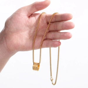 Handheld view of a gold-plated box chain necklace featuring a wide circular ring pendant