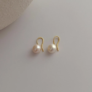 Detailed view of natural freshwater pearl earrings with minimalist gold metal hooks