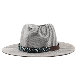 Detail of grey straw fedora hat featuring hand-woven ethnic beads on a brown leather band