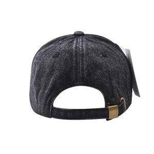 Detail view of washed denim baseball cap with adjustable metal buckle and vintage texture