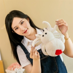 Soft white plush spider toy with red heart detail held by female model in home setting
