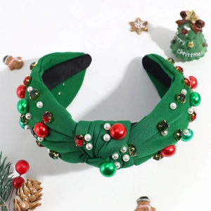 Detailed view of a green knotted Christmas headband featuring red beads and pearls