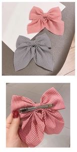 Detail of red and black checkered bow hair clips with a sturdy metal alligator clip back