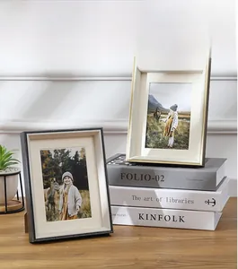 Detail of modern black textured and white gold-edged photo frames on a wooden desk