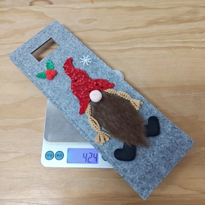 Detail of Christmas gnome wine bottle topper in grey felt with red sequined hat and beard