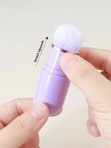 Detail showing the portable capsule makeup brush being stretched upwards for adjustment