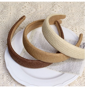 Detailed weave texture of woven headbands in brown and beige on a lace tablecloth