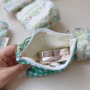 Détail macro de la fermeture éclair blanche et motif de feuilles sur pochette en coton