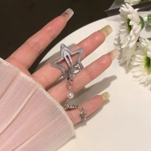 Close-up of star hair clip with dangling pearl chain and smiley face star charm