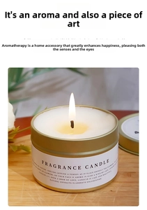 Close-up of a soy wax scented candle in a gold tin on a wooden tray with floral accents