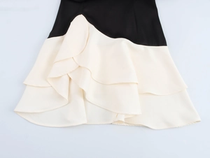 Détail de l'ourlet à volants superposés sur cette jupe trapèze contrastée noir et crème