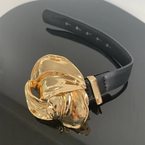 Modieuze zwarte lederen armband met grote gouden metalen gesp in de vorm van een bloem