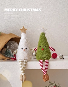 Detail of plush Christmas tree dolls with striped long legs and star toppers on table