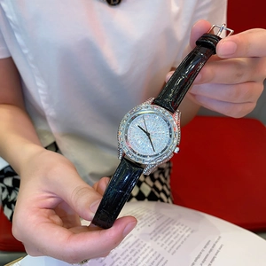 Luxury women's quartz watch with full diamond bezel and black leather strap on model's hand