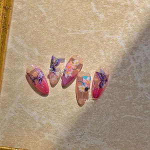 Détails de faux ongles en amande avec motifs papillons violets et fleurs roses