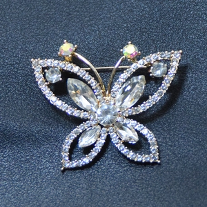 Broche papillon élégante avec cristaux et opales sur fond de cuir noir texturé