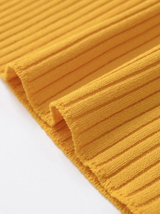 Detailed macro view of yellow ribbed knit fabric texture and vertical stripe pattern