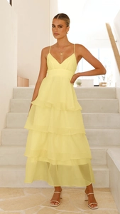 Detail of ruffled layers and tiered chiffon hem on a yellow backless evening dress