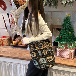 Detail of plush fleece bucket bag showing colorful geometric patterns and festive decor