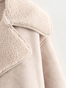 Gros plan détaillé sur la texture en suédine et polaire de la veste couleur crème