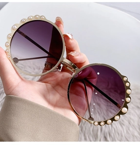 Detail of round sunglasses featuring purple gradient lenses and white pearl embellishments