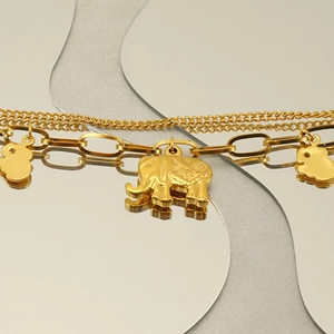 Detail shot of golden elephant pendant on 18k gold plated stainless steel bracelet