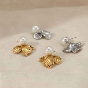 Elegant floral leaf pearl earrings in gold and silver finish on silk background