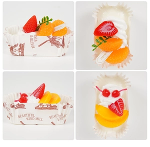 Macro detail of artificial fruit cupcake models featuring strawberries and cherries
