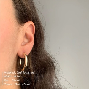 Model wearing 25mm gold C-shaped stainless steel hoop earrings with 4mm width
