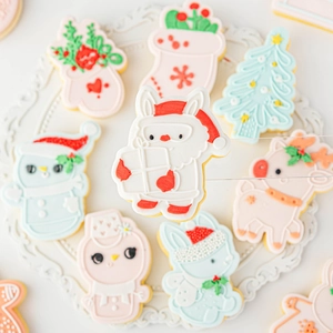 Pastel Christmas fondant cookies with reindeer and snowman shapes on ceramic tray