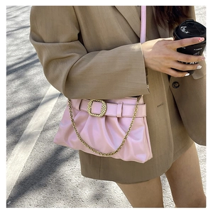Détail du sac plissé rose avec boucle dorée tressée et fine bandoulière chaîne