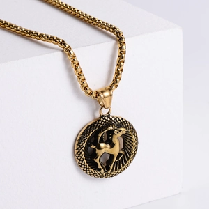 Macro detail of a 18K gold plated stainless steel Capricorn zodiac pendant on a pedestal
