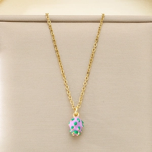 Close-up of gold stainless steel necklace with purple and green dragon fruit enamel charm
