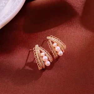 Vintage silver needle earrings with three pearls and crystals on red fabric