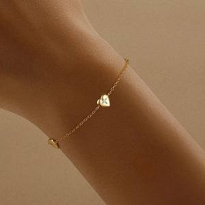 Macro shot of gold heart bracelet with sparkling starburst cubic zirconia on wrist