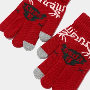 Detail of red knitted touchscreen gloves with festive jacquard patterns and gray tips