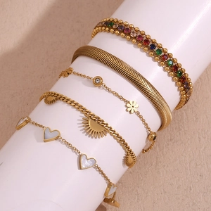 Detail of 18K gold-plated multi-layer bracelet set with heart charms and zircon stones