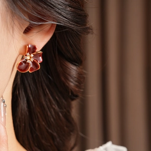 Close-up of vintage red enamel flower earrings with gold edges and zircon centers