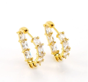Macro shot of gold stainless steel hoop earrings with channel-set baguette cubic zirconia