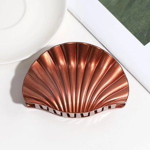 Close-up of a metallic brown shell-shaped hair claw with glossy finish and sparkling coating