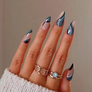 Almond-shaped press-on nails with green abstract swirl patterns on an elegant hand model