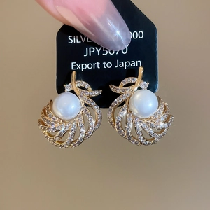 Detail of 18k gold plated silver earrings with pearl inlay and radiant shell pattern
