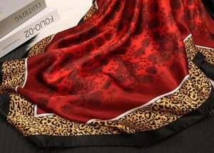 Detailed texture of satin square scarf featuring floral patterns and leopard print details