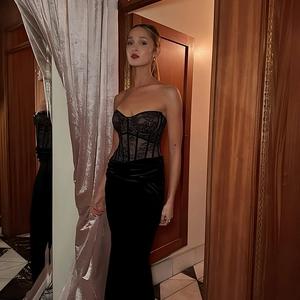 Detail von schwarzer Spitze und Samt am eng anliegenden Netzkleid mit Korsett-Design