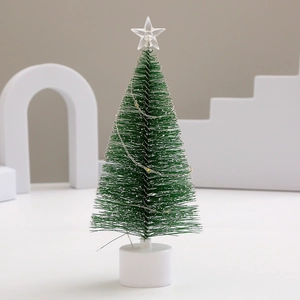 Close-up of a mini frosted Christmas tree with LED string lights and a star topper