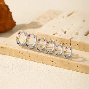 Three pairs of S925 sterling silver hoop earrings with colorful gemstones on stone base