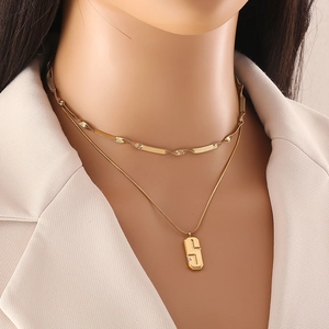 Minimalist gold-tone double layer geometric necklace with irregular pendant on a model